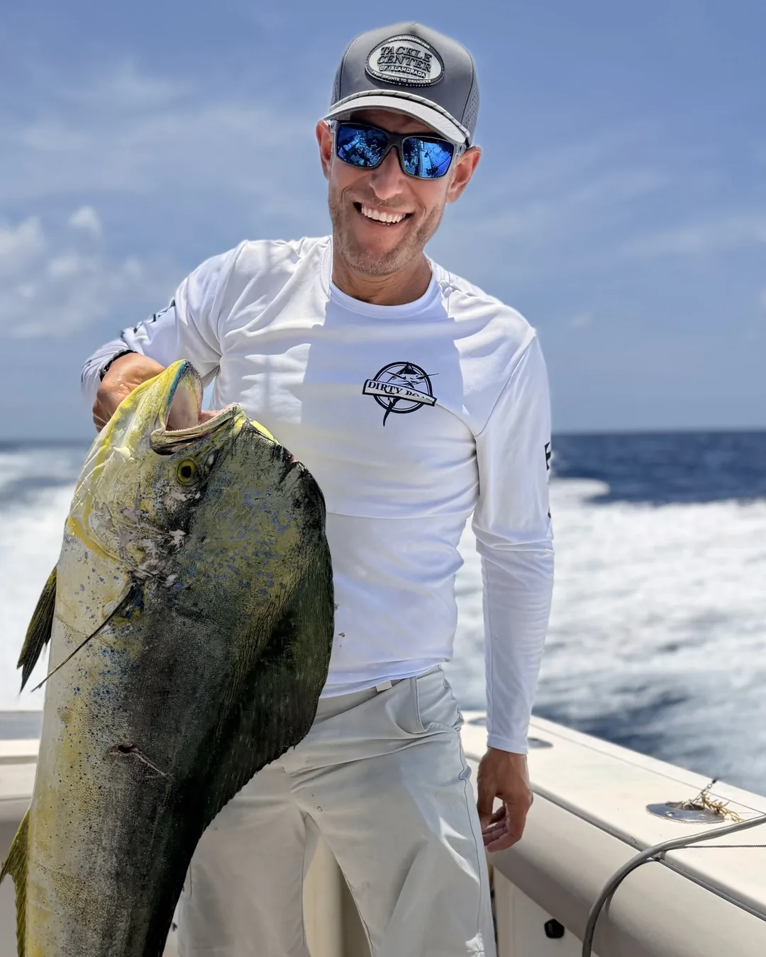 Alan Lanham offshore on a charter boat, holding a mahi.